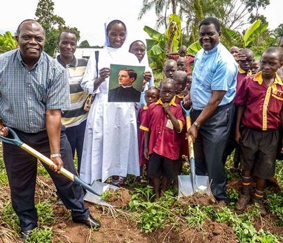 A group of people standing in a field with a man holding a shovel