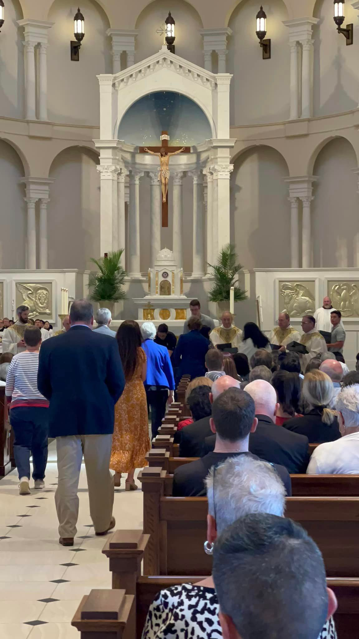 A group of people are walking down the aisle of a church