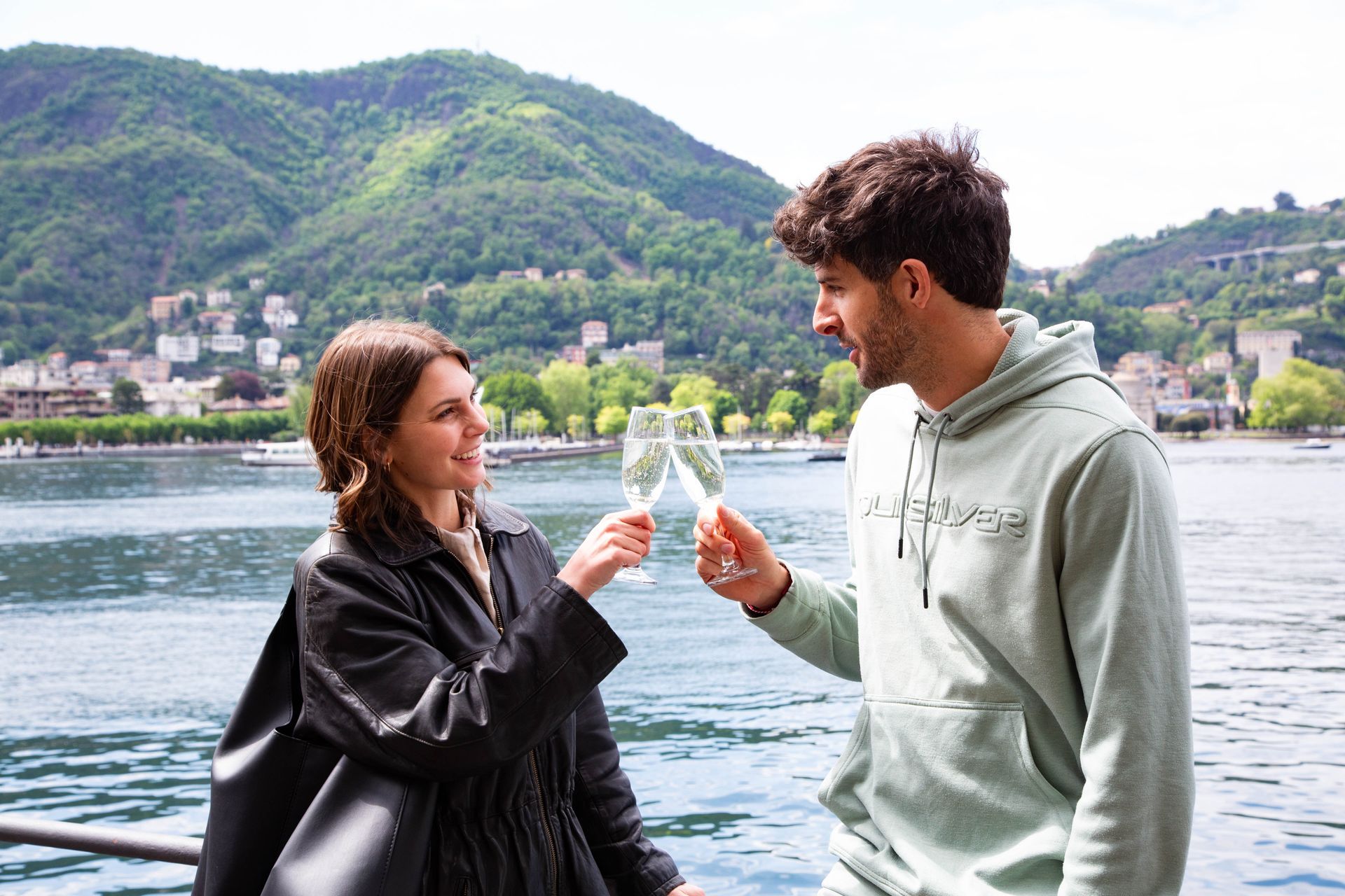 Couple toasting prosecco on Lake Como, Italy.