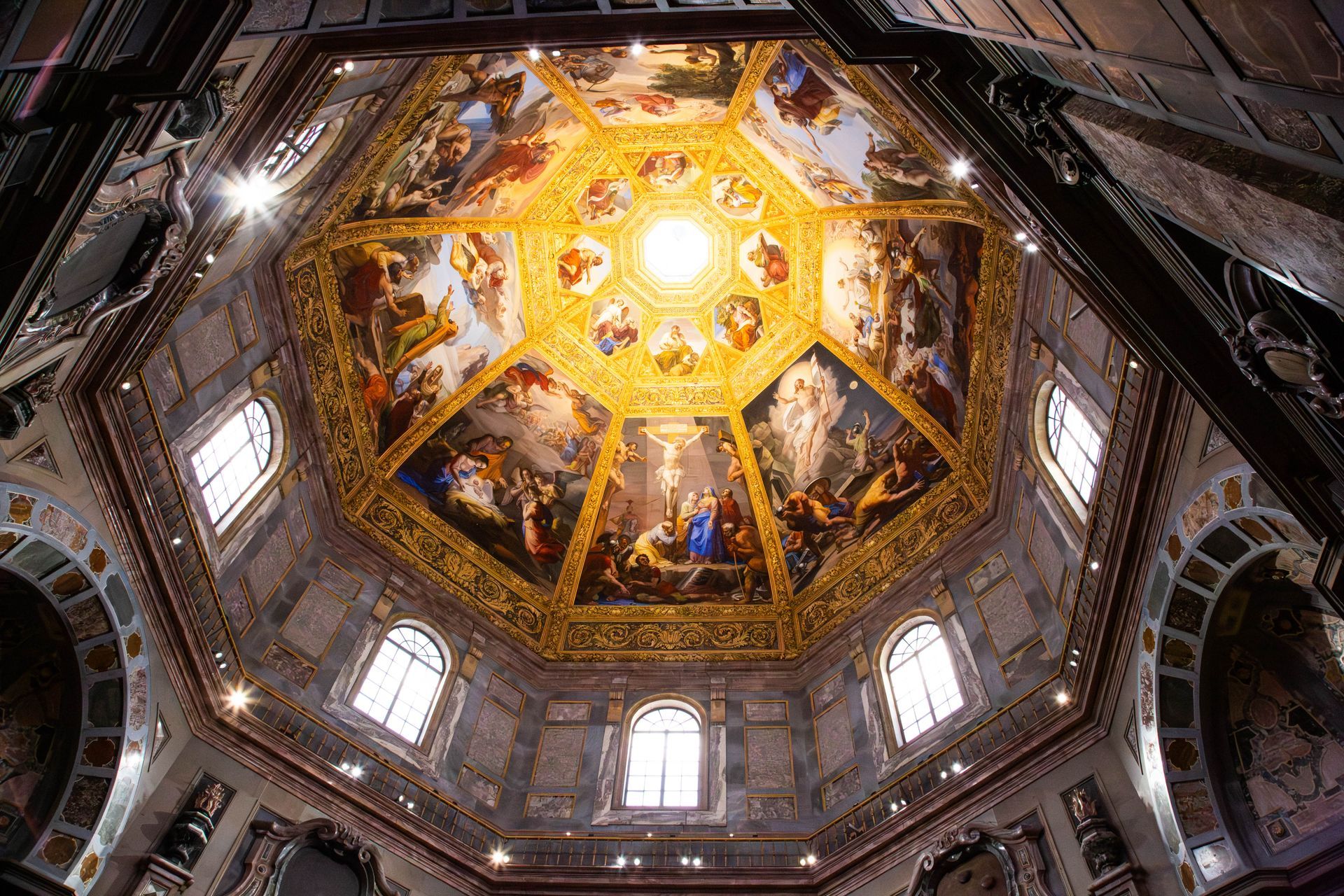 Ornate cathedral dome with gold mosaics and bright central skylight