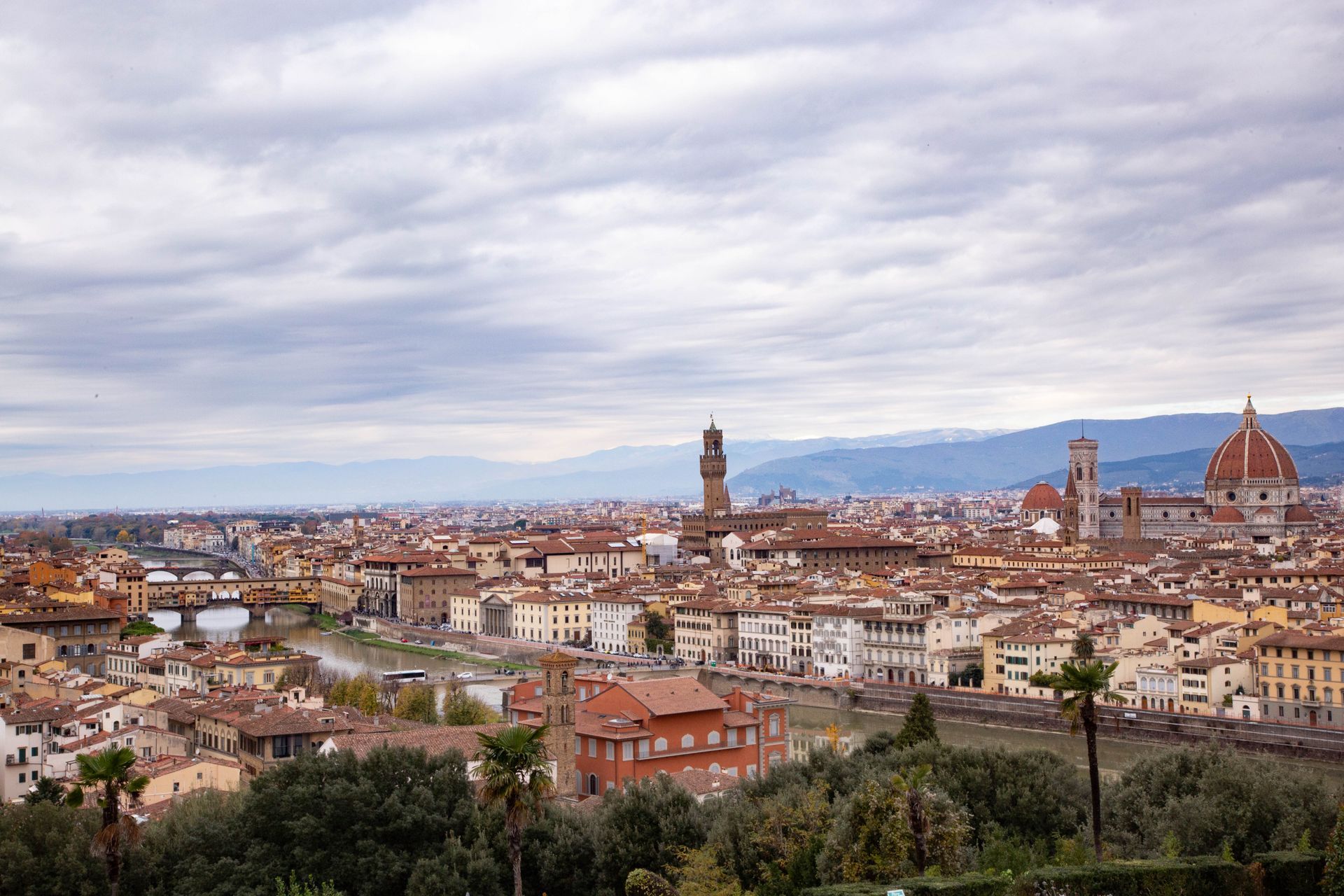 Panoramic view of Florence, Italy, with the Duomo and historic city rooftops under a cloudy sky