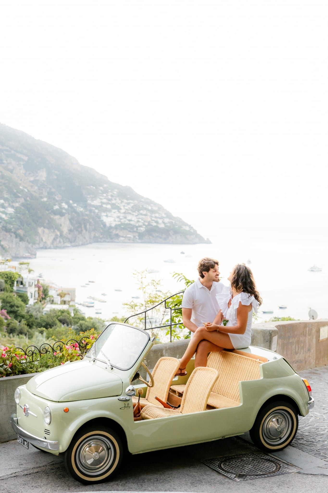 Couple posing in Fiat 500 on the Amalfi Coast road.