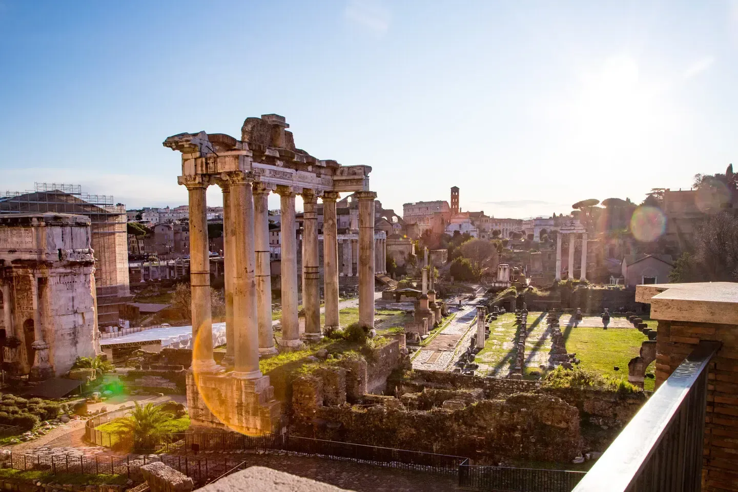 Ruins of the Roman Forum in Rome, Italy, with columns, buildings, and a sunny sky.
