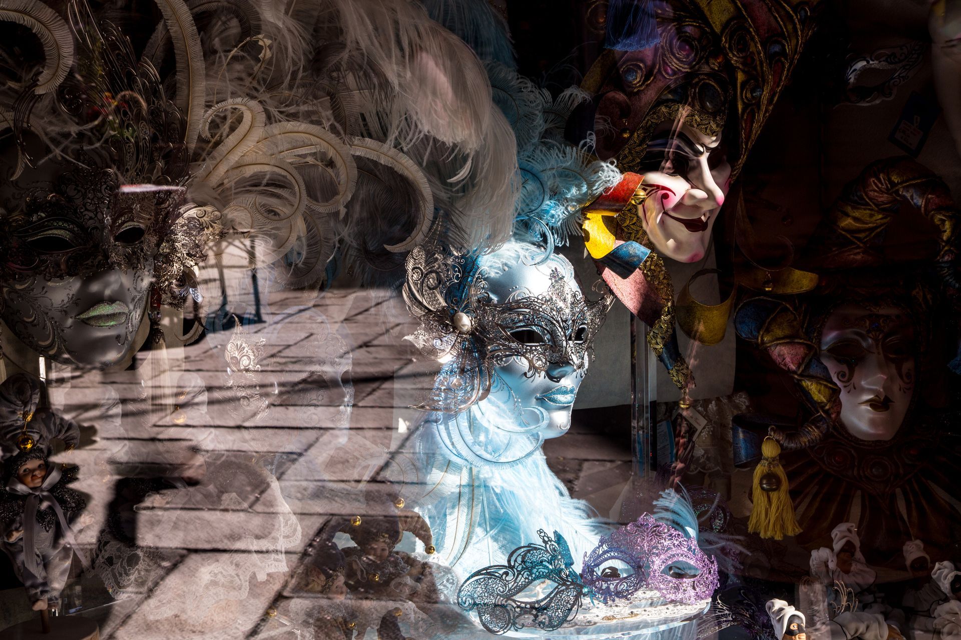 Crowded display of colorful masks and figurines in a dim shop or market stall