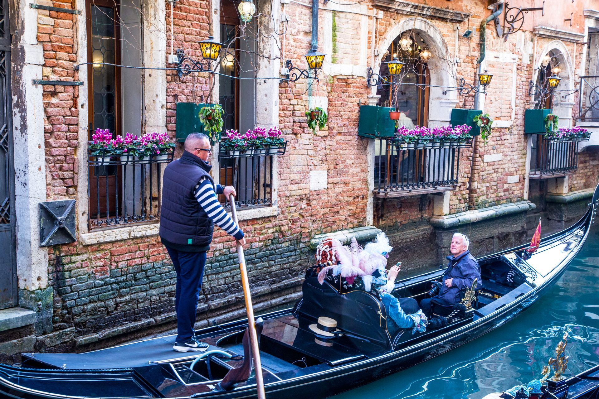 People in a gondola in a canal in Venice.