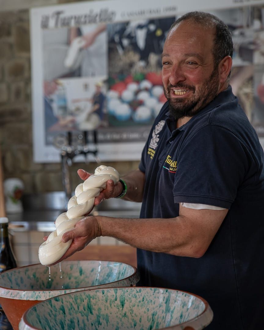 Man smiling while making mozzarella cheese.