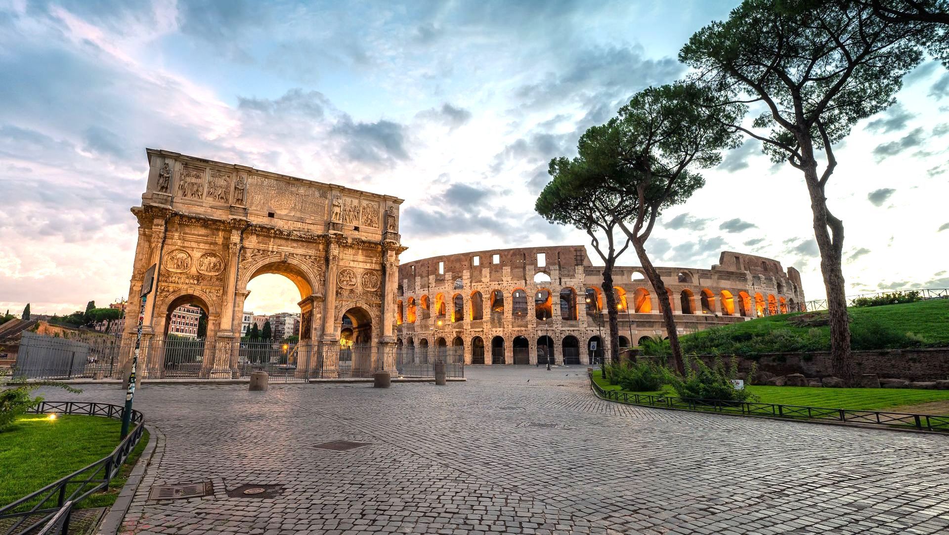 Arch of Constantine and Colosseum in Rome, Italy, at dusk.