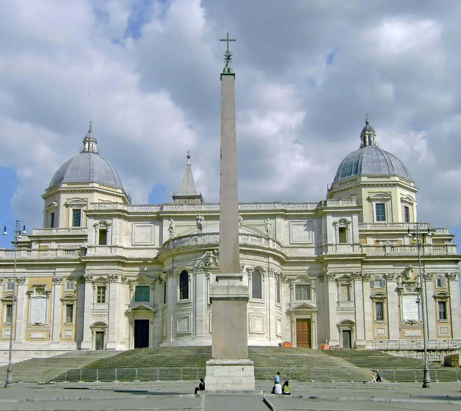 White facade of Basilica di Santa Maria Maggiore with a tall obelisk in front.