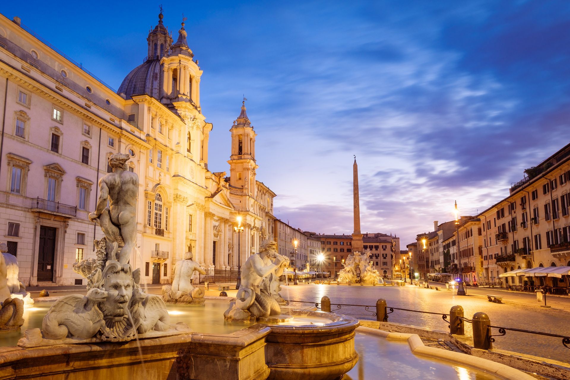 Trevi Fountain at night, Rome, illuminated facade with sculptures, water cascading into pool.