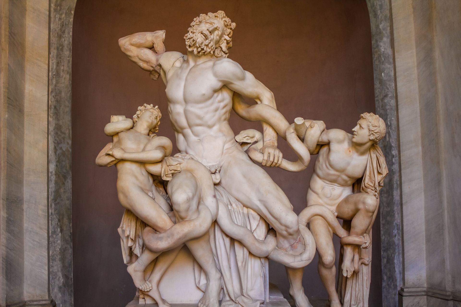 Marble sculpture of Laocoön and his sons being attacked by serpents. Figures are in agony.