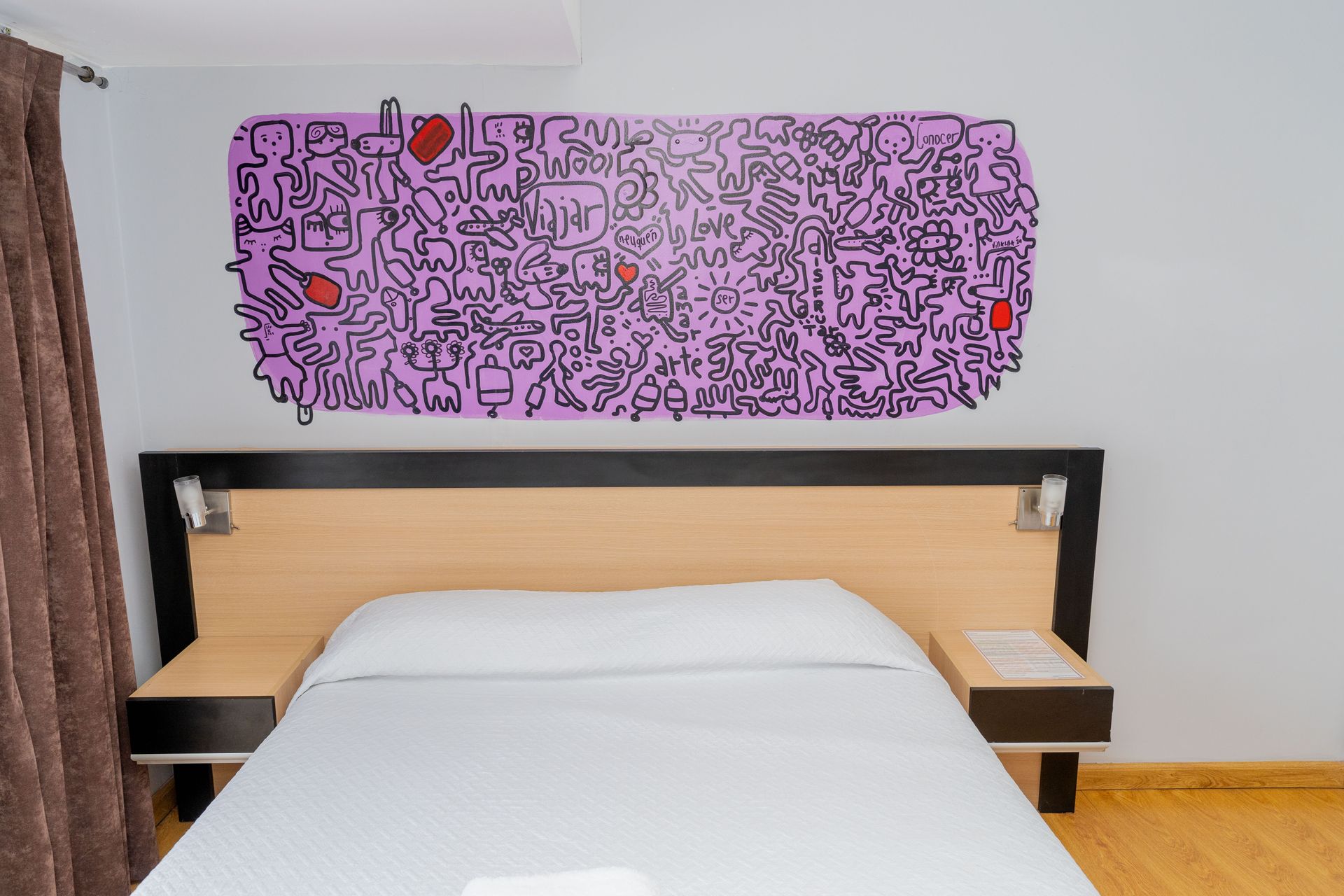 Bedroom with bed, abstract art, and wooden headboard.