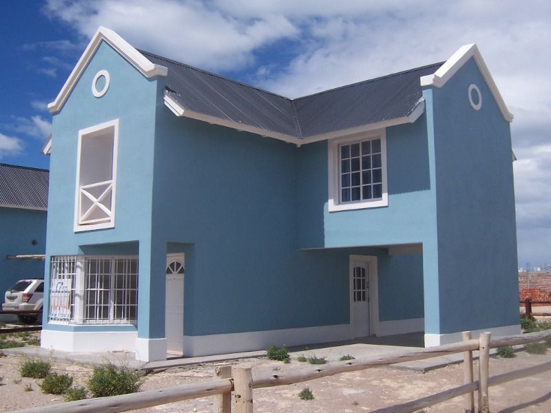 Two-story light blue house with white trim, black roof, and small front porch.