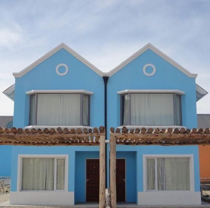 Two light blue houses with white trim, doors, and roofs, under a partly cloudy sky.