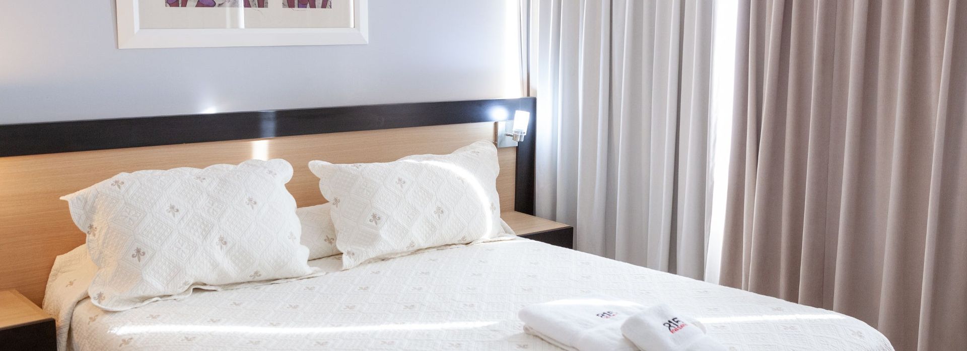 Bedroom with a bed, pillows, and curtains.