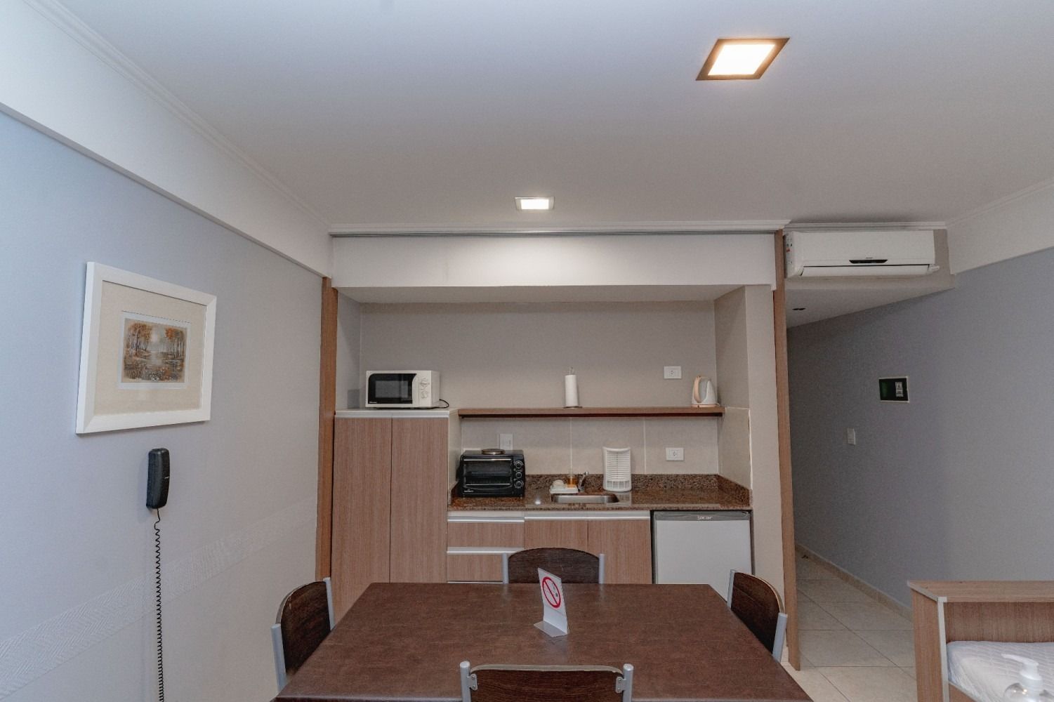 Small studio apartment with kitchenette and dining table.