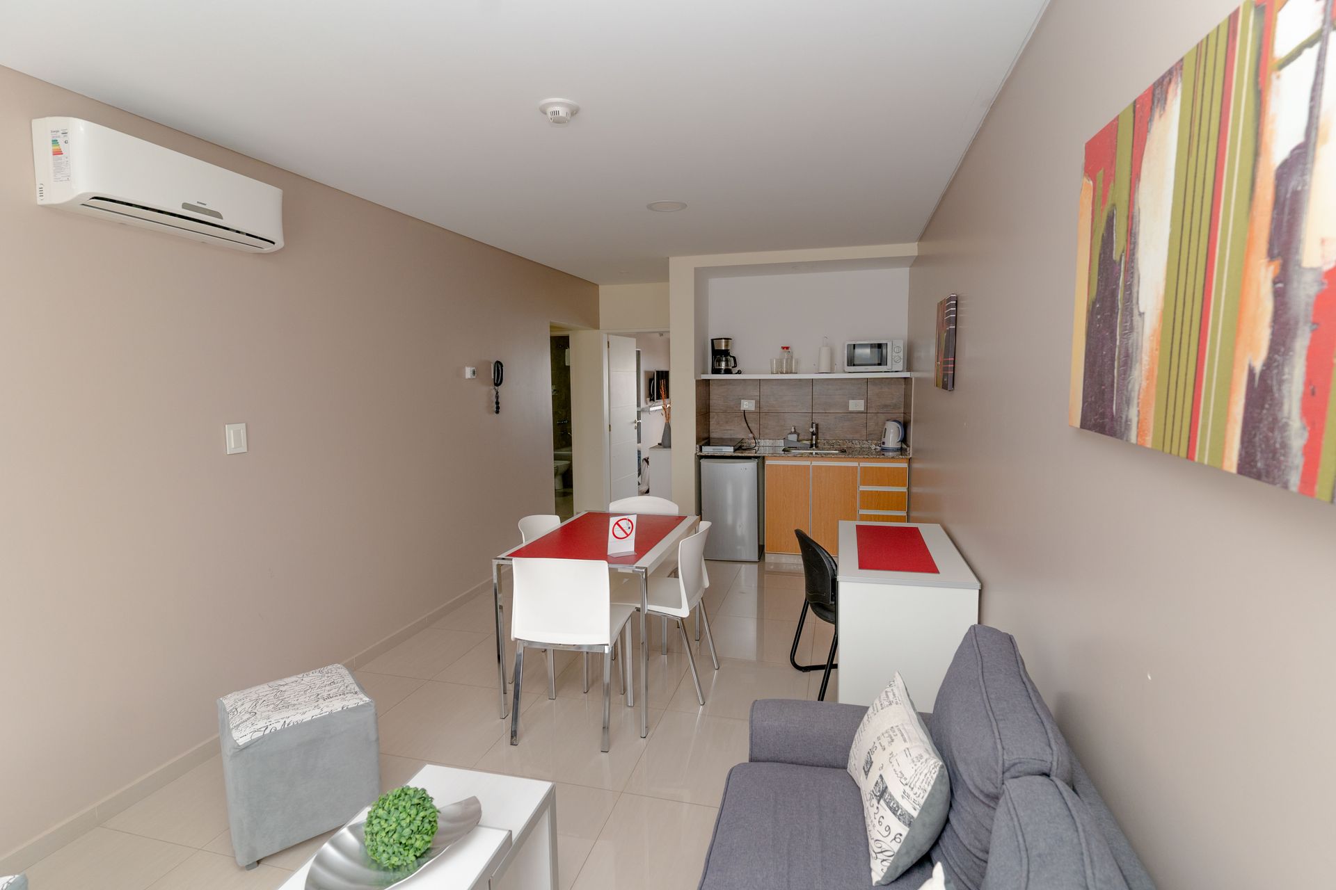 Small apartment with kitchen, dining area, and living room in neutral tones.