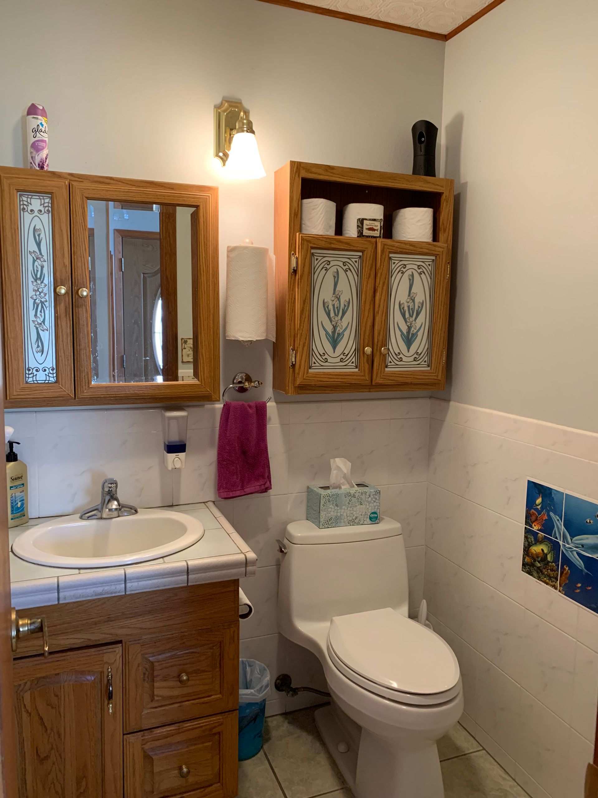 A bathroom with a toilet a sink and a mirror