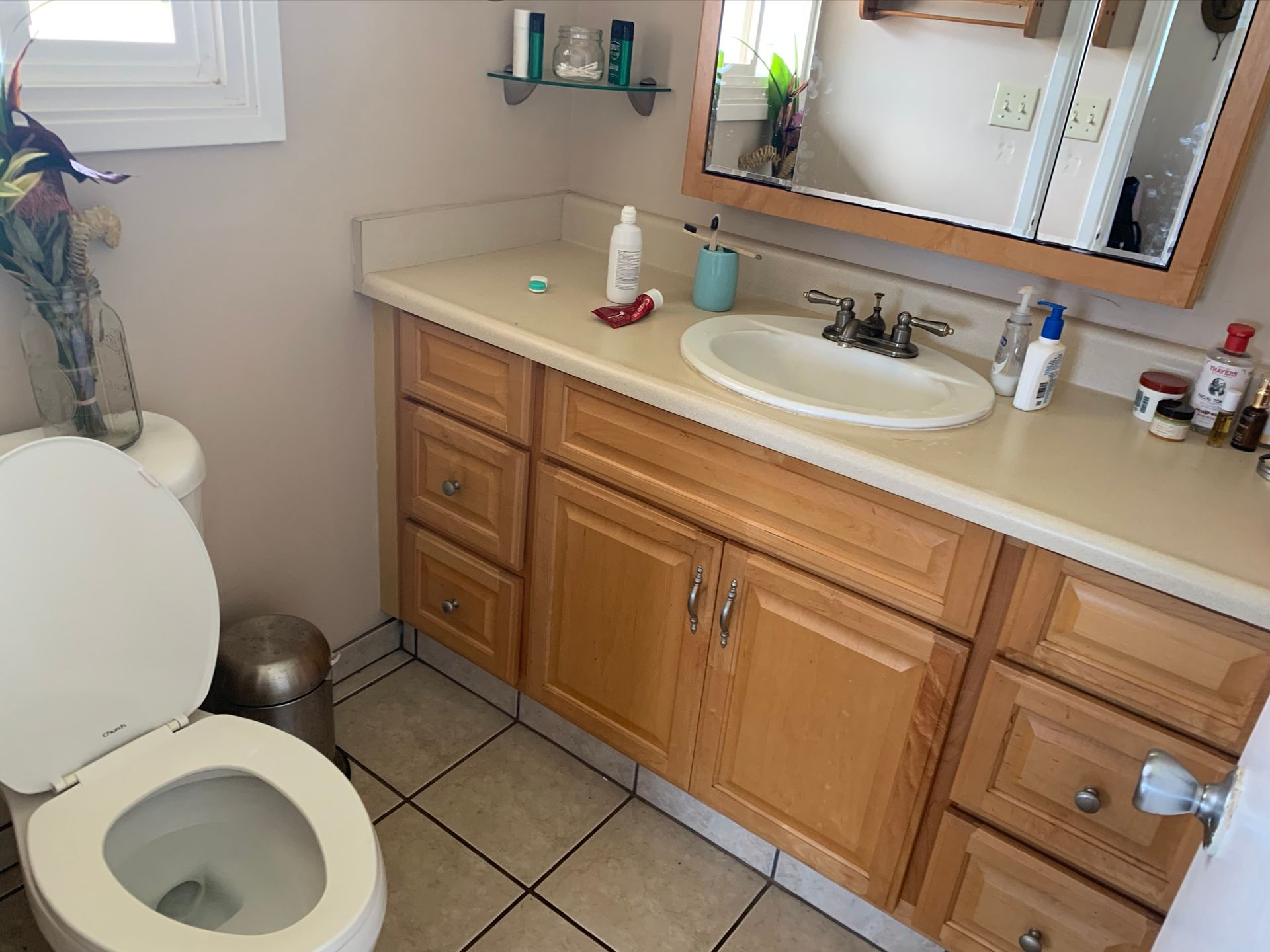 A bathroom with a toilet , sink and mirror
