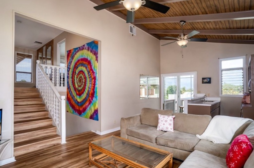 A living room with a couch , coffee table , and stairs.