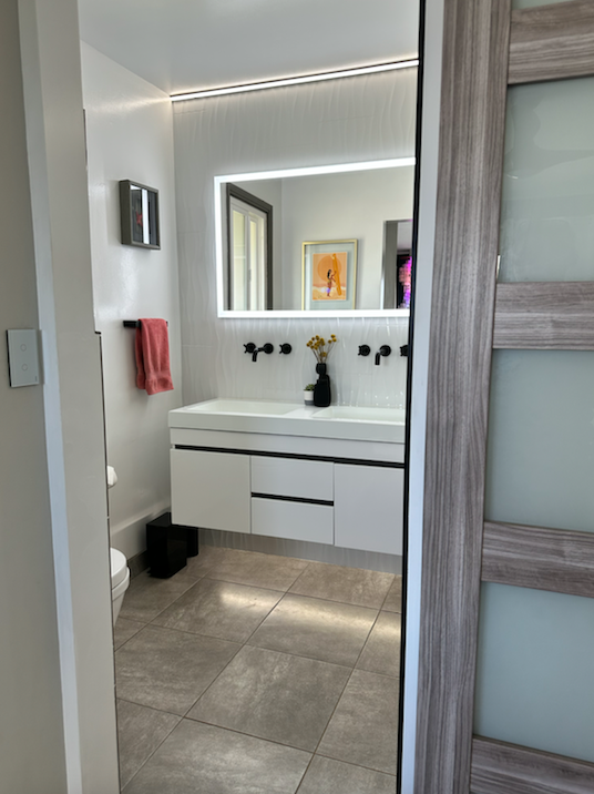 A bathroom with a sink , mirror and toilet