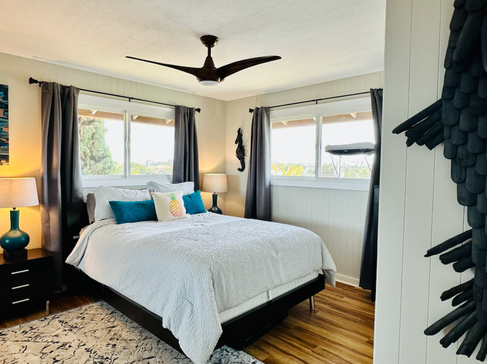 A bedroom with a large bed and a ceiling fan.