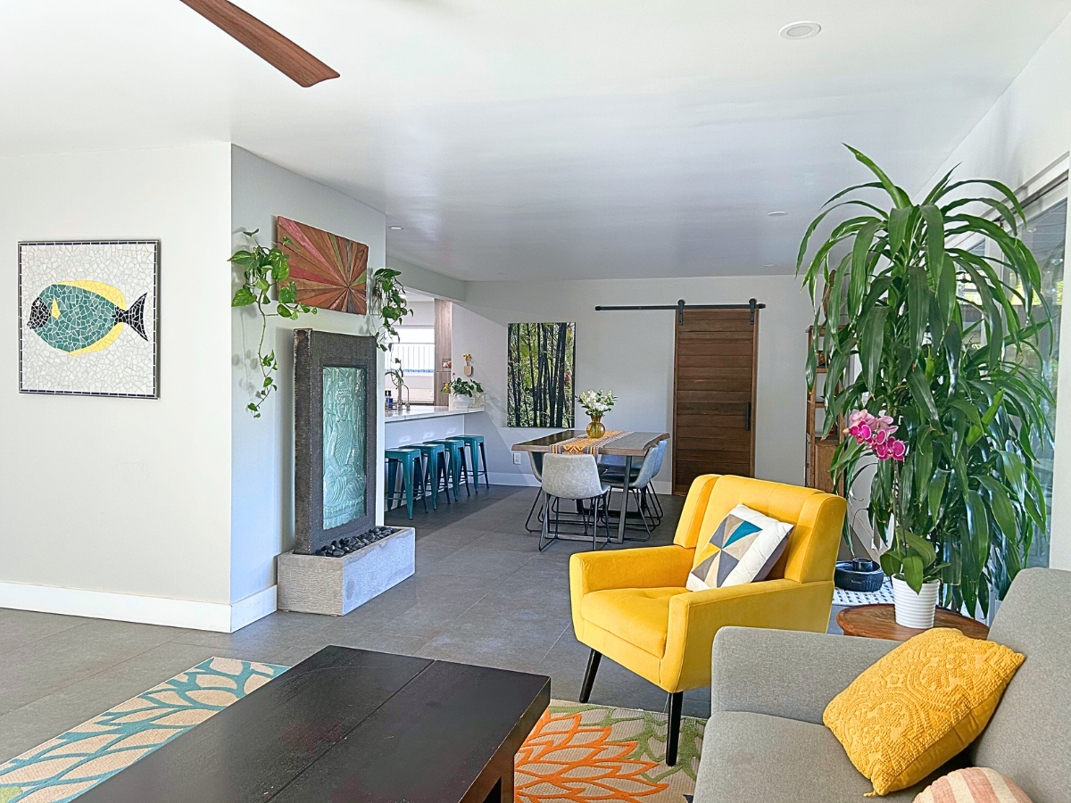 A living room with a couch , chair , coffee table and a ceiling fan.