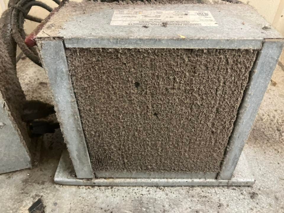 Weathered concrete utility box with a rough textured front panel and metal frame outdoors