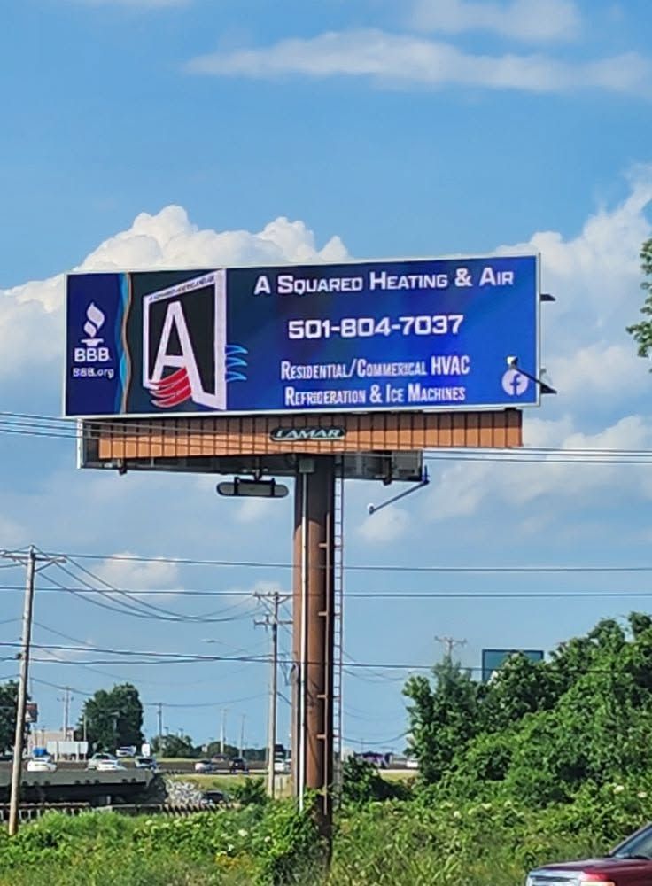 Billboard for A Source Heating & Air with phone number and services, against a blue sky.