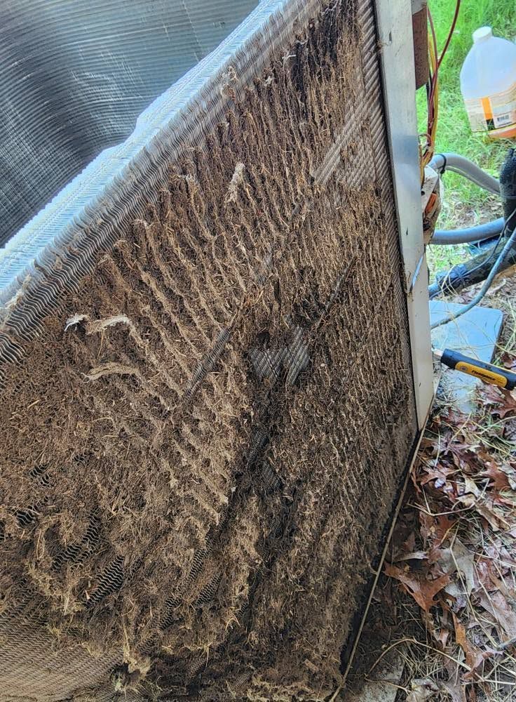 Dirty air conditioner condenser coil covered in dust and debris outdoors