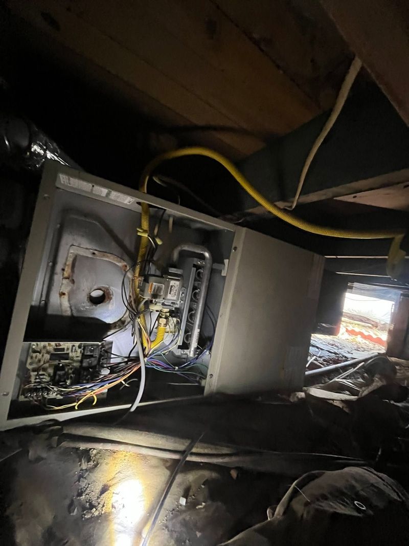 Open computer case with exposed wiring and components in a dim room, cables scattered around.
