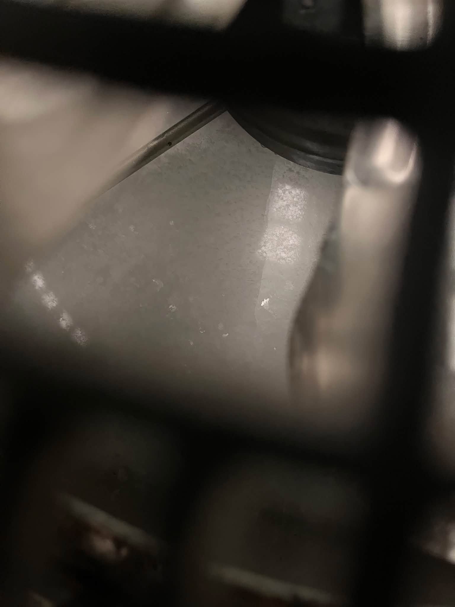 Close-up of a blurred gray surface seen through dark bars or framing.