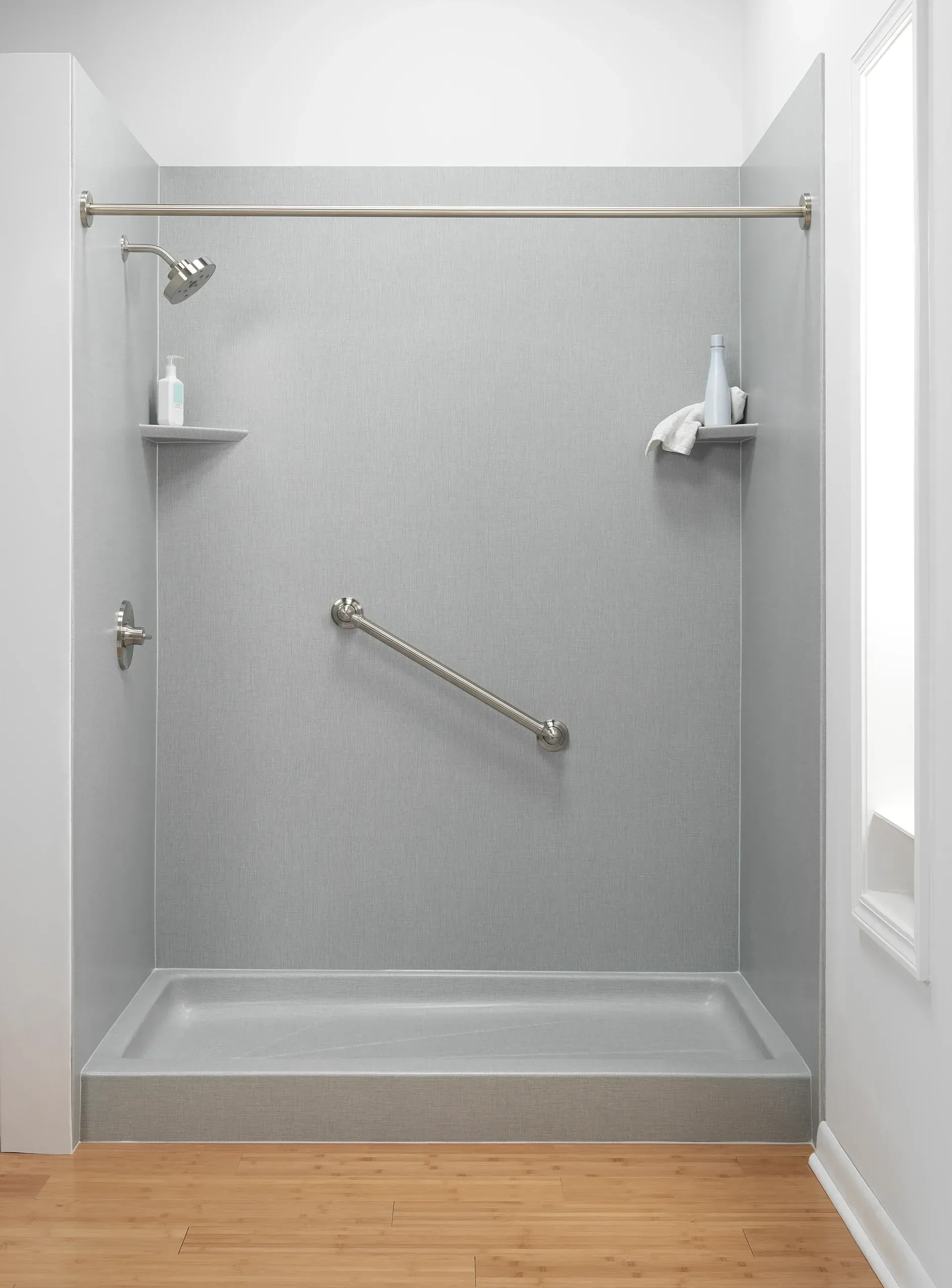 A gray stylish shower with shower seating and grab bars.