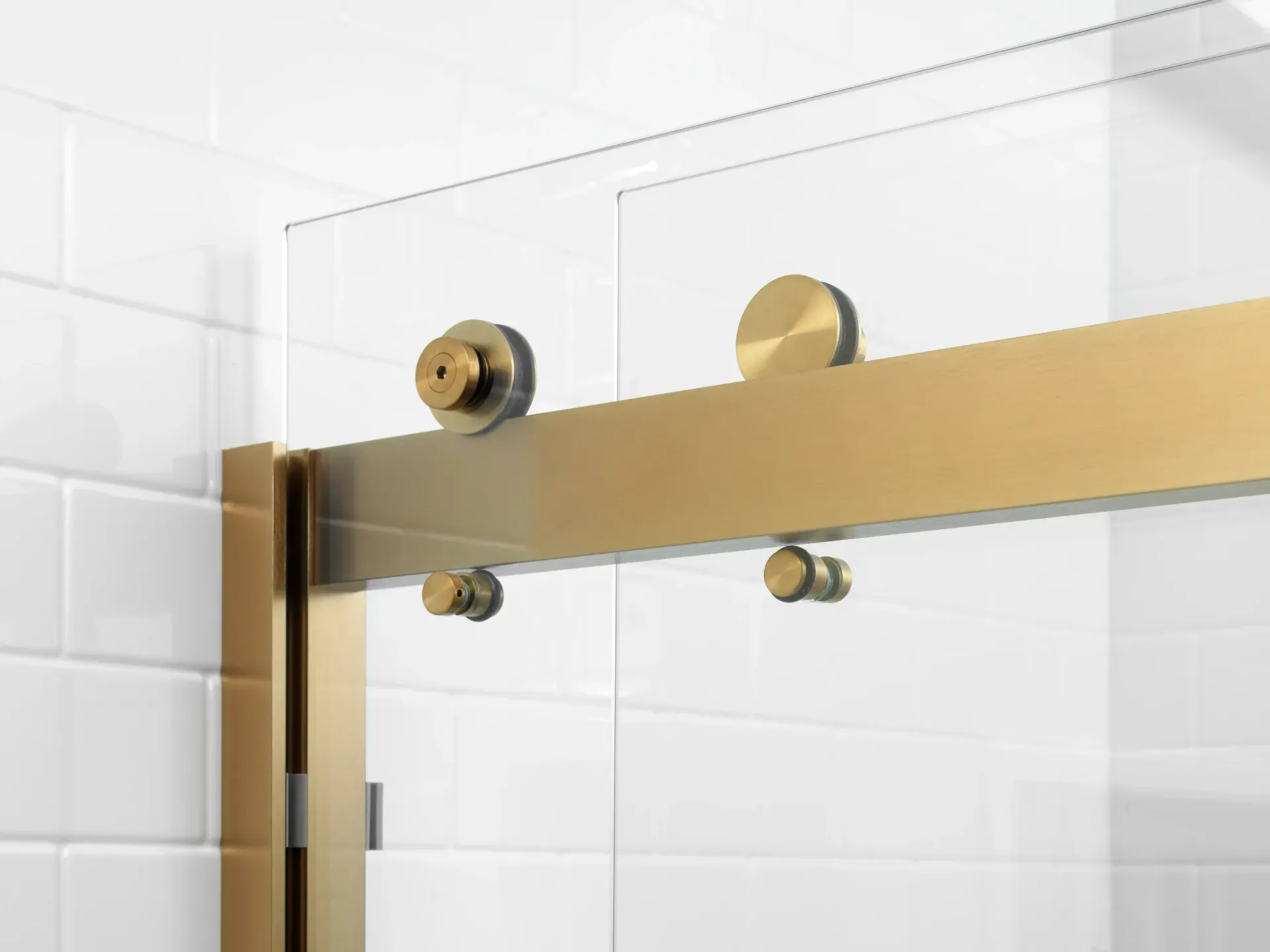 A close-up shot of brass rolling hardware for a shower door.