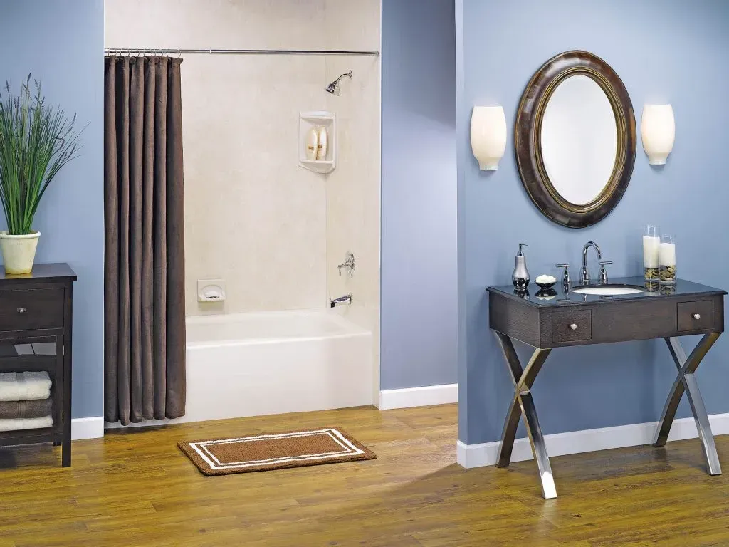 A bathroom with blue walls and dark wooden furniture with a white and cream colored shower.