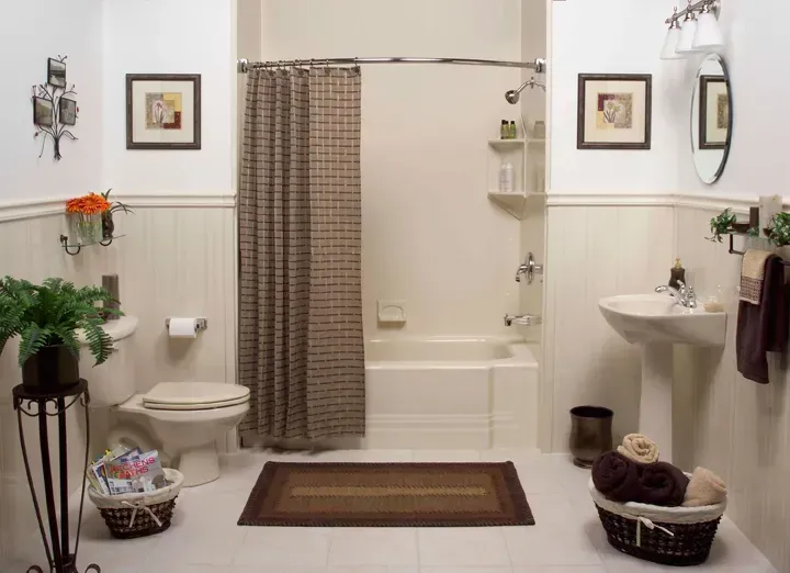 A bathroom with light porcelain and tan shower curtain.