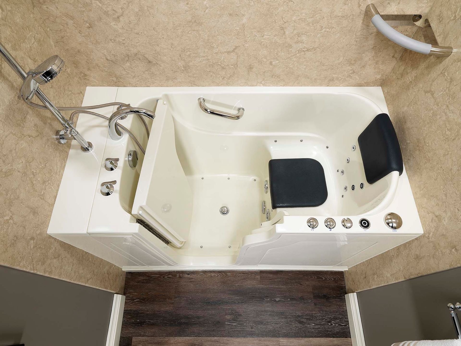A walk-in white bathtub with silver handles and black seating cushions.