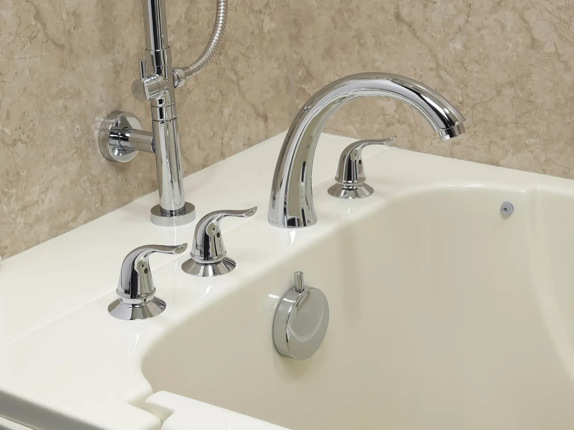 A close up of silver hardware on a bathtub.