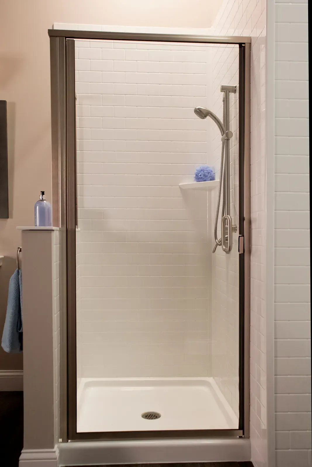 A white tiled shower with silver hardware