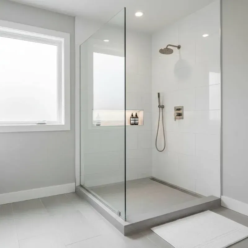 A white bathroom with a stand up shower with clear walls.