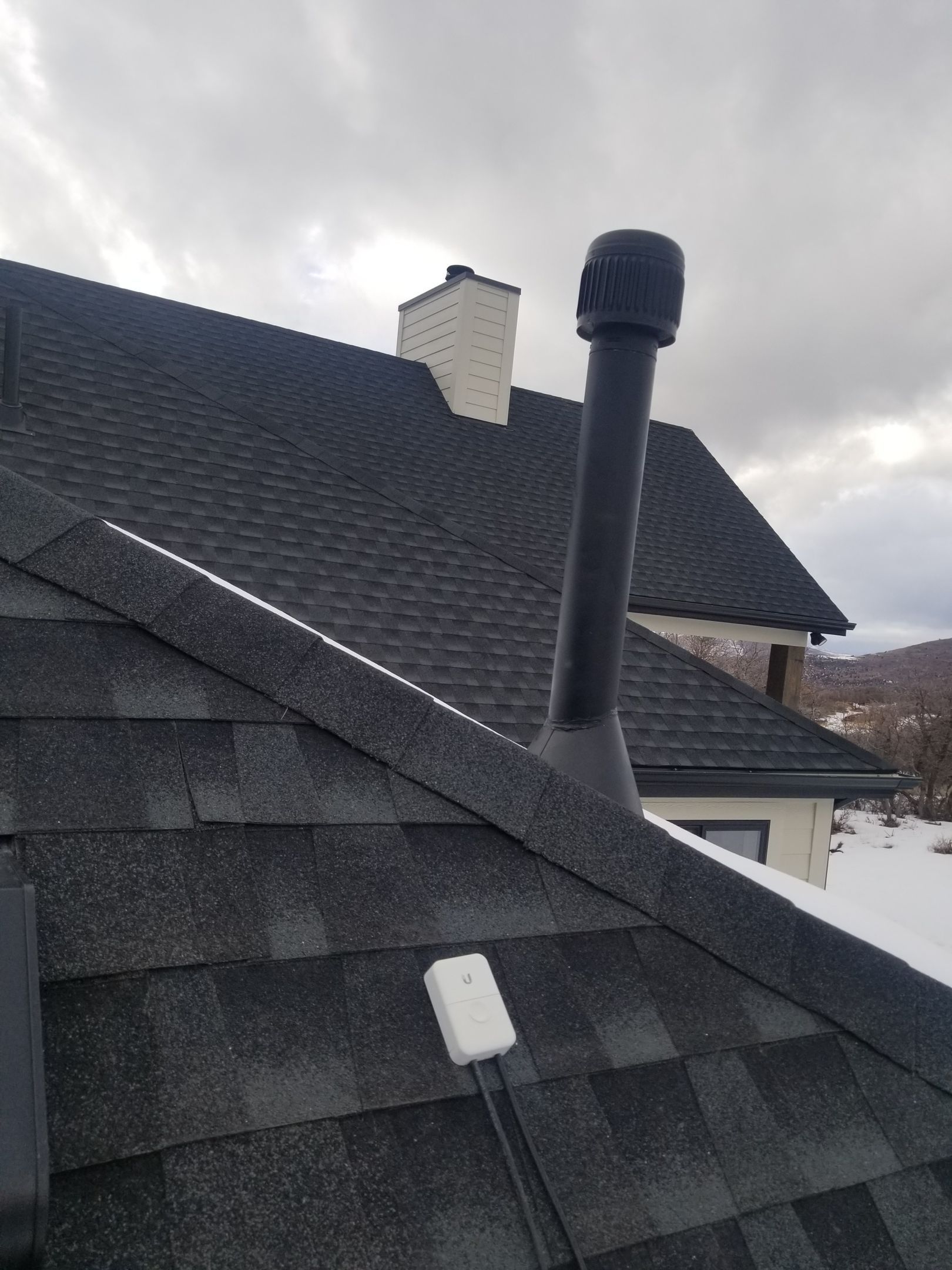 A close up of the roof of a house with gutters and chimneys.