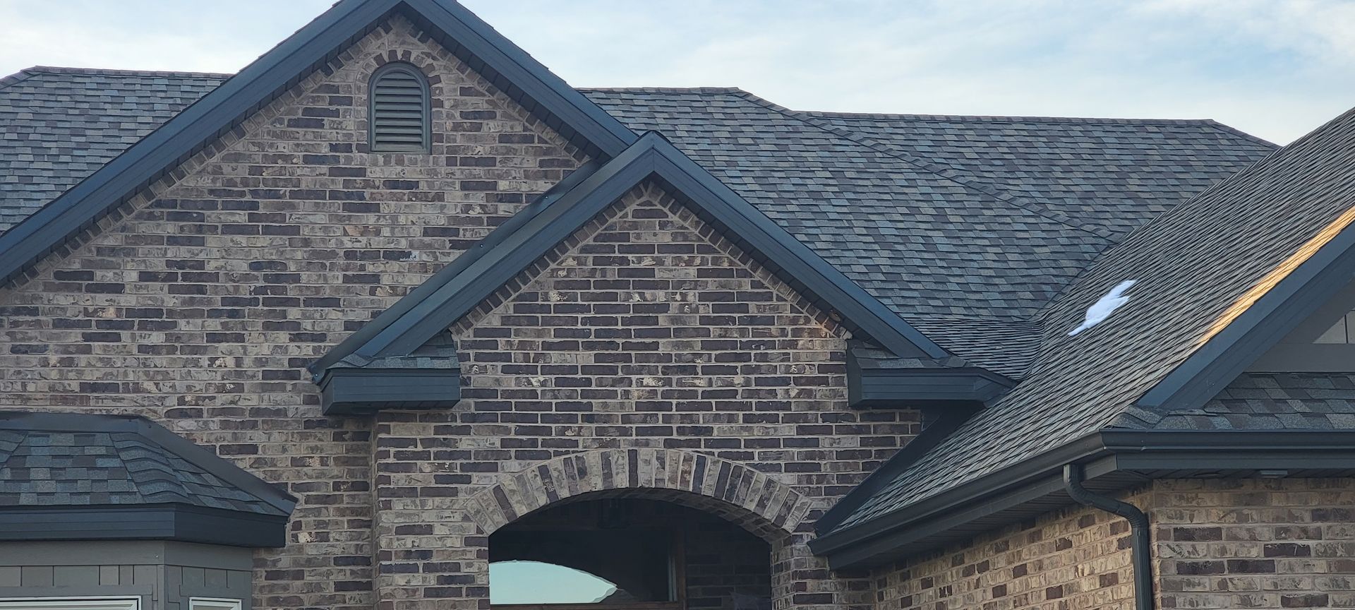 A close up of a black gutter on a wooden roof.