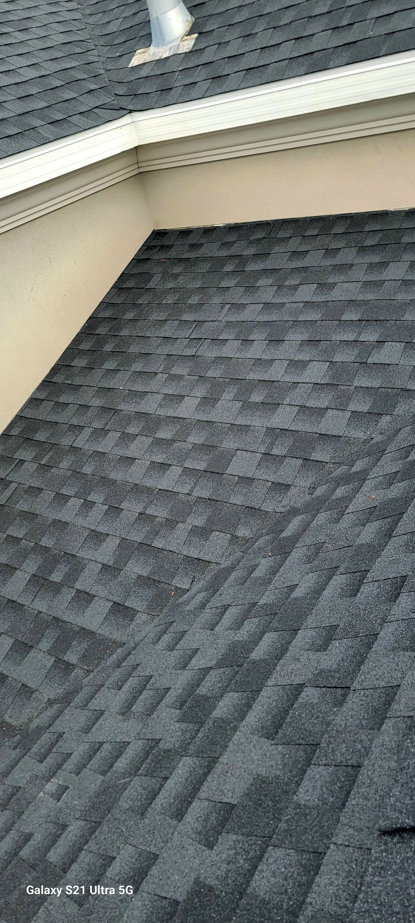 A man is working on the roof of a house.
