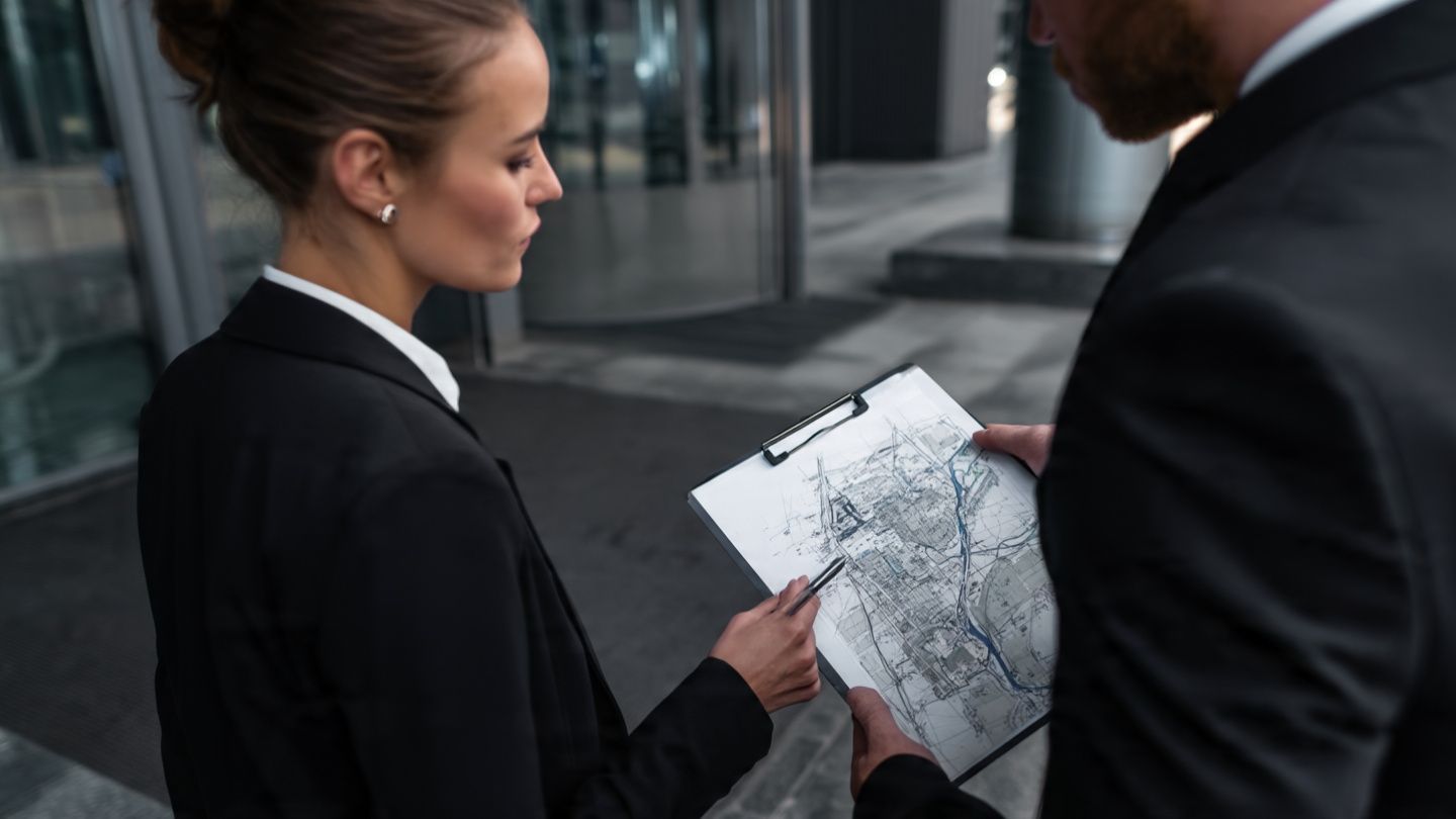 Business people reviewing a map outside a modern building