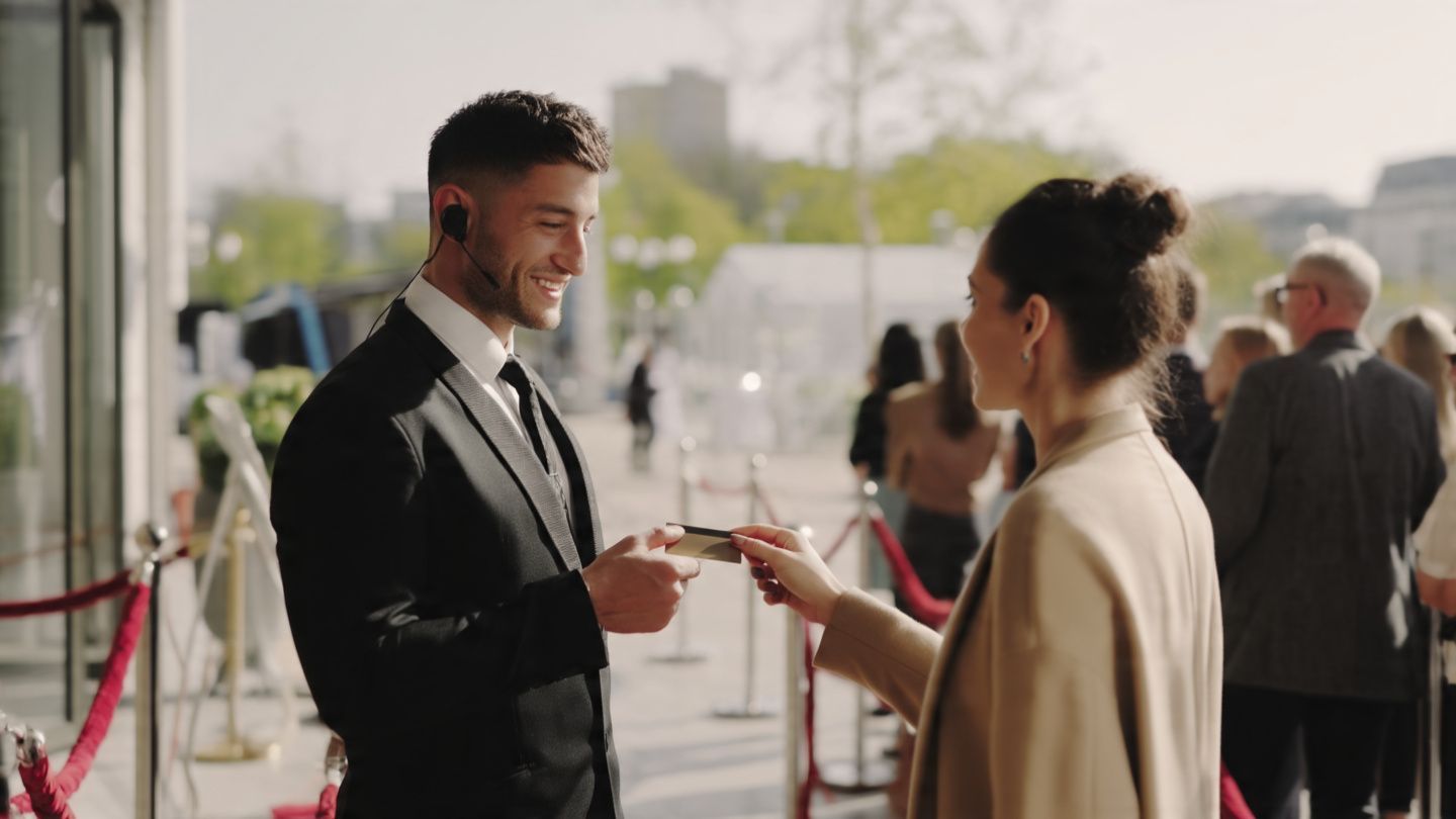 Man in black suit receiving an award from a woman at a red-carpet event