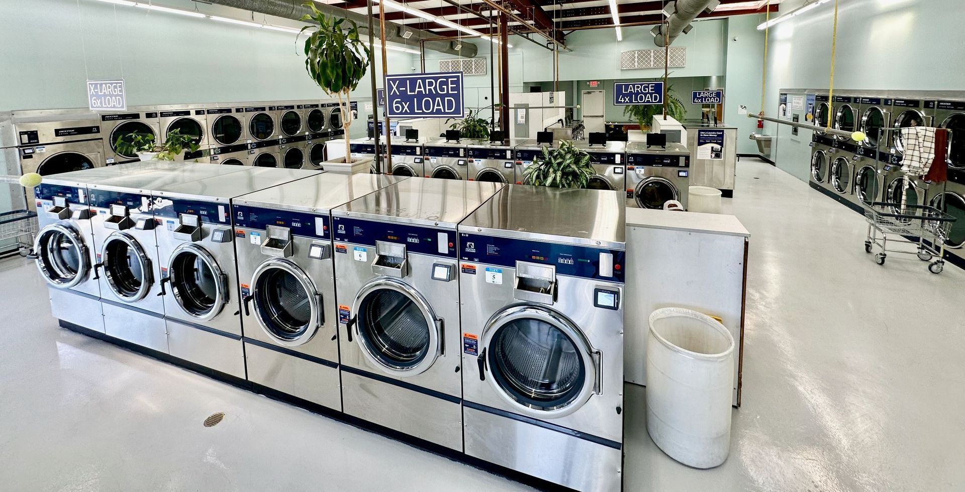 image of clean and spacious laundromat with folding tables and rolling carts
