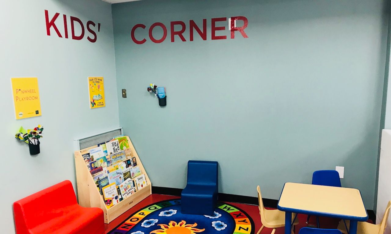 image of cute children's area with bookshelf, colorful rug and small chairs