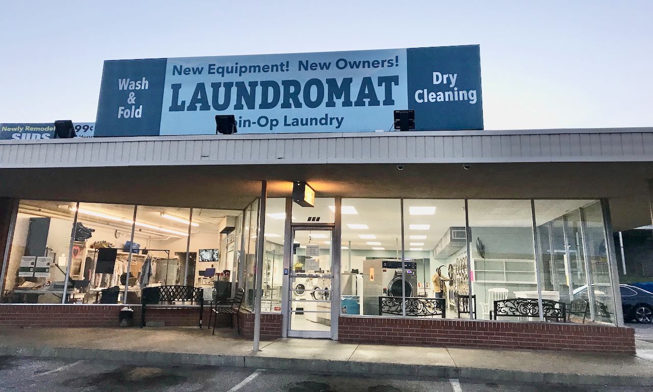 image of a laundromat with sign reading New Equipment New Owners Laundromat