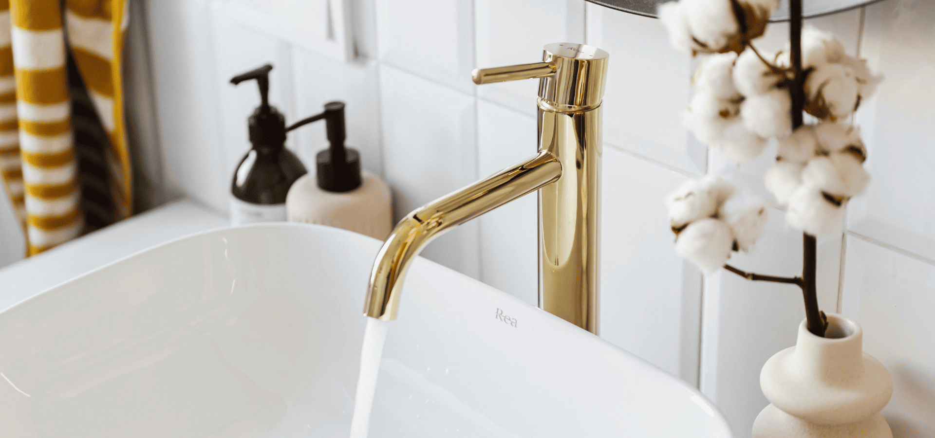 A golden faucet replacing an old faucet on a sink