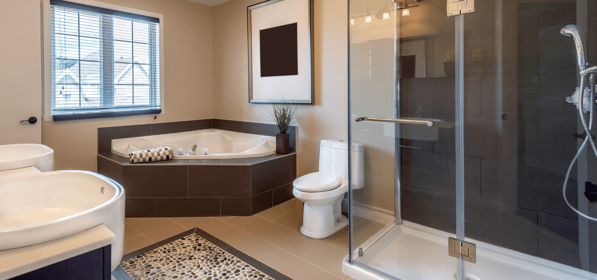 Large full bathroom with bathtub, toilet, and shower on one side and double vanities on the other side