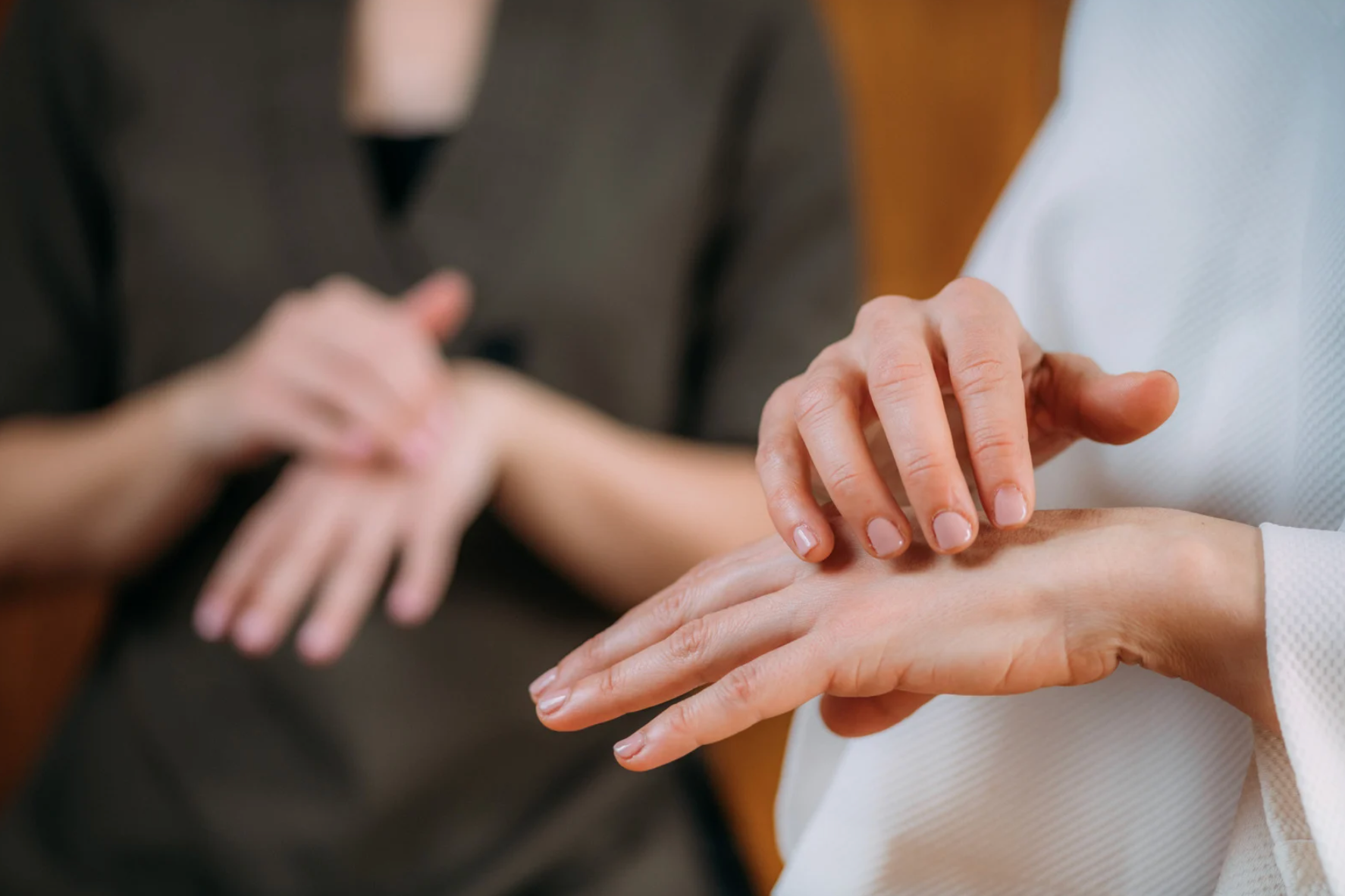 Gros plan sur des mains effectuant des techniques de massage. Une personne se fait masser la main par une autre.